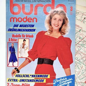 May include: A vintage Burda Moden magazine cover featuring a woman in a red dress with a black belt. The cover has text in German, including "Die neuesten Frühlingsfarben" and "Modelle für Urlaub & Reise." The magazine is dated March 1987.