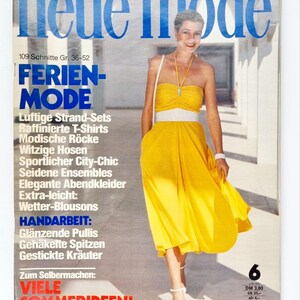 Puede incluir: Una portada de revista vintage con una mujer en un vestido amarillo sin tirantes y cinturón blanco. El título "neue mode" está en azul. El texto incluye "FERIEN-MODE" y "VIELE SOMMERIDEEN!" en alemán.