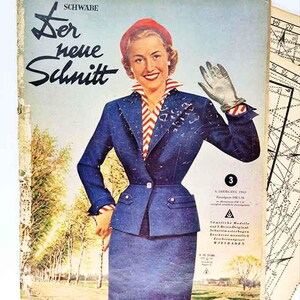 Op de afbeelding: Vintage magazinecover met een vrouw in een blauw pak en rode hoed. De cover toont de tekst "Der neue Schnitt" en "SCHWABE". De vrouw lacht en zwaait, met een landschap en naaipatronen op de achtergrond.