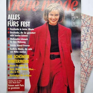 May include: A December 1988 issue of the magazine Neue Mode featuring a person wearing a bright red blazer and matching trousers over a black top. The cover includes the text Alles fürs Fest and Die schönste Wintermode alongside a pattern sheet.