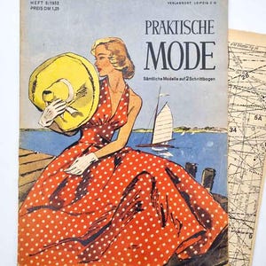 Könnte beinhalten: Vintage Zeitschriften-Cover mit dem Titel "PRAKTISCHE MODE" mit einer Frau in einem roten Polka-Dot-Kleid und gelbem Hut. Die Illustration zeigt eine Szene am Meer mit einem Segelboot. Das Zeitschriften-Cover hat deutschen Text und einen Preis.