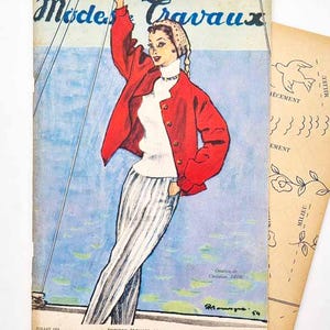 May include: A vintage July 1954 issue of the magazine Modes et Travaux featuring a fashion illustration of a person wearing a red jacket, white turtleneck, and pinstriped trousers. The cover includes the text Creation de Christian DIOR.