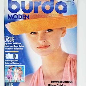 May include: A magazine cover with a woman wearing an orange hat. The magazine title "burda MODEN" is in large blue letters. The cover includes German text, with the issue number and date visible.
