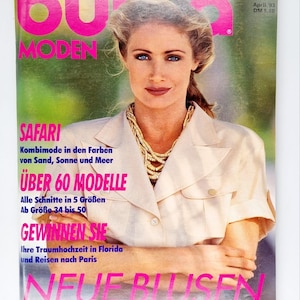 Puede incluir: Una portada de revista con una mujer que lleva una camisa blanca de estilo safari con un collar de cuentas superpuesto. La revista se titula "Burda Moden" y el texto de la portada dice: "Safari, Kombimode in den Farben von Sand, Sonne und Meer, Über 60 Modelle, Alle Schnitte in 5 Größen, Ab Größe 34 bis 50, Gewinnen Sie, Ihre Traumhochzeit in Florida und Reisen nach Paris, Neue Blusen".