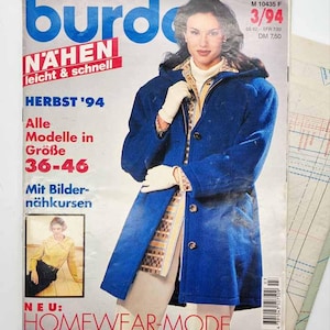 May include: A vintage copy of "Burda" magazine, with a woman wearing a blue coat on the cover. The magazine's title, "Burda", is in large blue letters. The cover also features German text, including "HERBST '94" and "HOMEWEAR-MODE".