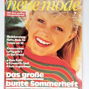 Könnte beinhalten: Ein Magazincover mit einer Frau mit blonden Haaren, die einen rot-grünen gestreiften Pullover trägt. Das Magazin heißt "neue mode" und hat den Text "Das große bunte Sommerheft" unten.