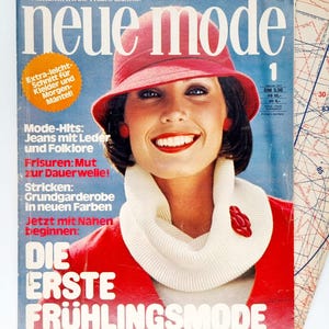 May include: A magazine cover featuring a woman wearing a red sweater and a white turtleneck. The magazine is titled "neue mode" and the cover text reads "Die Erste Frühlingsmode" and "93 Schnitte Größe 34-52".