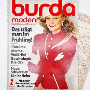 May include: A vintage Burda Moden magazine cover showing a woman in a red jacket with white detailing. The cover has German text, including the headline "Das trägt man im Frühling!" and other fashion-related content. A sewing pattern is visible.