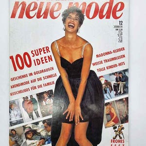 Può includere: Una copertina di rivista vintage con il titolo "neue mode" in rosso. La copertina presenta una donna in un abito nero, con testo tra cui "100 SUPER IDEEN" e altre frasi tedesche. La rivista è datata dicembre 1991.