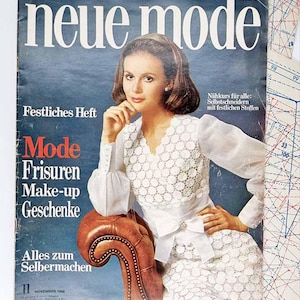 May include: A vintage magazine cover with the title "neue mode" in white. The cover features a woman in a white lace dress. Text includes "Mode, Frisuren, Make-up, Geschenke" and "November 1968". The background is a faded blue.