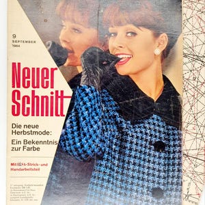 May include: A vintage magazine cover featuring a woman wearing a blue and black patterned sweater. The magazine is titled "Neuer Schnitt" and the text "Die neue Herbstmode: Ein Bekenntnis zur Farbe" is visible. The cover also includes the date "9 SEPTEMBER 1964".