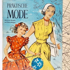 May include: A vintage magazine cover featuring two women in dresses. The magazine is titled "Praktische Mode" and the text "Sämtliche Modelle auf 2 Schnittbogen" is also visible. The cover features a blue sky background with a woman in a yellow dress and a white hat holding a white bag. A younger woman in a red and white floral dress is holding a blue paper lantern.