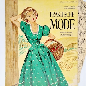 May include: A vintage magazine cover featuring a woman in a green and white polka dot dress holding a basket of cherries. The magazine is titled "Praktische Mode" and the text "Heft 5/1953 Preis DM1,25" is visible.