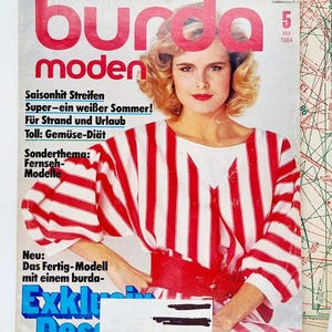 May include: A vintage magazine cover featuring a woman wearing a red and white striped shirt with a red belt. The magazine is titled "Burda Moden" and the cover text reads "Saisonhit Streifen Super-ein weißer Sommer! Für Strand und Urlaub Toll: Gemüse-Diät Sonderthema: Fernseh-Modelle Neu: Das Fertig-Modell mit einem burda-Exklu Des" The magazine is dated May 1984.
