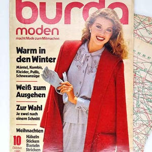 Könnte beinhalten: Ein Set aus drei Keramikbechern mit gesprenkelter, matter Oberfläche. Die Becher sind in Creme-, Hellgrau- und Dunkelgrautönen gehalten. Jeder Becher hat ein schlichtes, minimalistisches Design, ideal für Kaffee oder Tee.