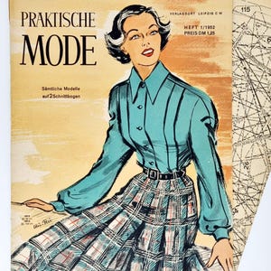 Op de afbeelding: Een vintage tijdschriftcover met een vrouw die een tealblauwe blouse draagt met een witte kraag en een geruite rok. Het tijdschrift is getiteld "Praktische Mode" met de tekst "Heft 1/1952 Preis DM 1,25" in de rechterbovenhoek.