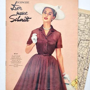 Könnte beinhalten: Ein Vintage-Magazin-Cover von 1957 mit dem Titel Schwabe Der neue Schnitt, das eine Person in einem dunkel-kastanienbraunen Kurzarmkleid mit plissiertem Oberteil, einem weißen Hut mit breiter Krempe, weißen Handschuhen und einer Perlenkette zeigt.