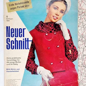 May include: Vintage fashion magazine cover featuring a woman in a red suit with a patterned collar and sleeves. The cover includes the text "Neuer Schnitt" and "Erste Herbstmodelle zeigen Pariser Chic", with the date August 1964.