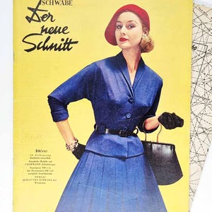 May include: A vintage magazine cover with a woman in a blue suit and red hat. The cover has German text, including "Der neue Schnitt" and "SCHWABE". The woman is holding a black purse and wearing black gloves.