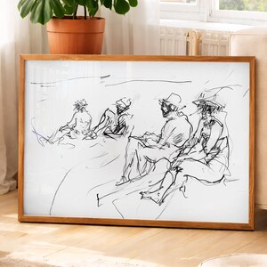 May include: A framed sketch of a group of people, rendered in black lines on a white background. The artwork depicts figures in hats and casual attire, seated in a relaxed outdoor setting. The frame is made of light brown wood.