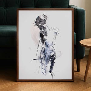Puede incluir: Lámina de arte abstracto enmarcada en madera. La obra presenta una representación a modo de boceto de una persona, utilizando tonos negros, blancos y azules. La figura se ve de espaldas, creando una sensación de intriga. El marco es de color marrón cálido.