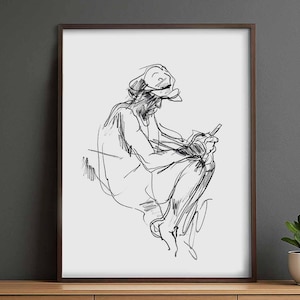May include: A framed monochrome sketch depicting a seated figure engrossed in writing or drawing. The artwork is a minimalist line drawing, featuring a hat and loose clothing. The frame is a dark brown colour.