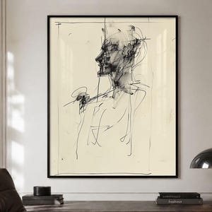 May include: Abstract black and white sketch of a person's profile, framed in a black border. The artwork is on a cream-colored background. The drawing style features loose, expressive lines, creating a modern art piece.