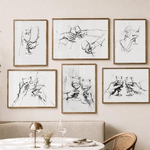 May include: Six framed art prints with black and white line drawings of wine glasses and hands toasting. The artwork is displayed on a beige wall above a table with a white tablecloth, creating a sophisticated dining room aesthetic.