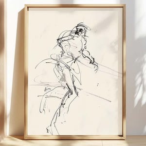 May include: A framed black and white sketch of a figure in motion. The artwork features loose, expressive lines, creating a dynamic and abstract representation. The frame is a light wood color, adding a natural touch to the piece.