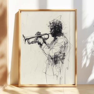 May include: A framed black and white sketch of a musician playing a trumpet. The artwork features loose, expressive lines, capturing the essence of the subject. The artwork is displayed in a light-colored wooden frame, adding a touch of warmth to the piece.