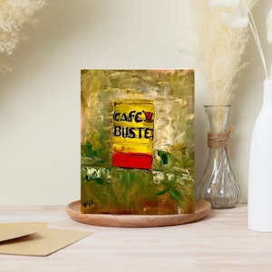 May include: An abstract painting of a coffee can with the words "CAFE BUSTE" in black on a yellow background. The bottom of the can is red, and the background is a mix of green and gold. The artwork is displayed on a wooden tray.