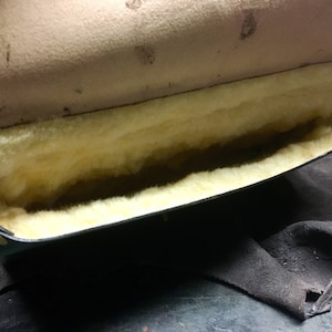 May include: A black leather case with a soft, white, fluffy lining. The case is open and the lining is visible.