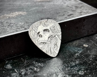 Skull scrollwork sterling silver guitar pick made of 925 sterling silver with a scrollwork skull design engraved into it