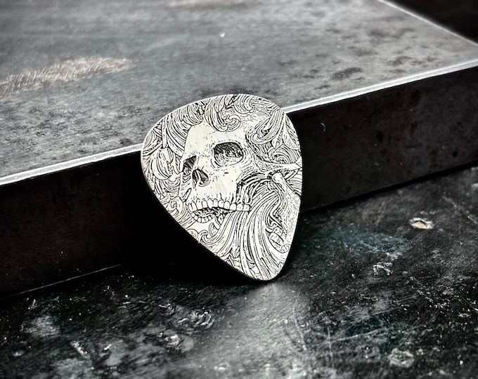 Skull scrollwork sterling silver guitar pick made of 925 sterling silver with a scrollwork skull design engraved into it