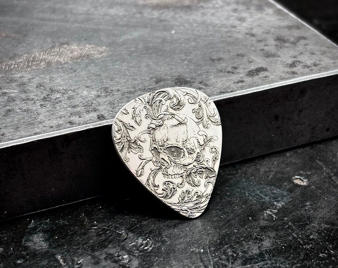 Skull scrollwork sterling silver guitar pick made of 925 sterling silver with a scrollwork skull design engraved into it