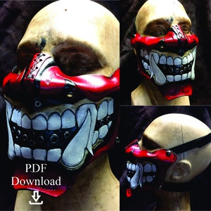 Puede incluir: Una máscara de cuero roja y blanca con una expresión feroz, con dientes afilados y una lengua larga. La máscara tiene detalles negros y está diseñada para cubrir la boca y la nariz.