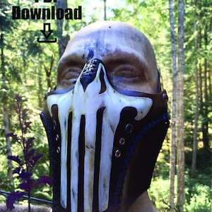 May include: A black and white skull mask with a leather strap and metal rivets. The mask is worn on a mannequin head. The background is a blurred image of trees.