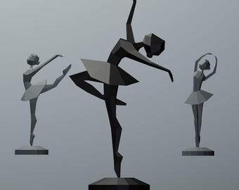 May include: Three geometric ballerina sculptures in shades of grey and black. The central figure is dark grey, posed mid-dance with one arm raised. The other two are lighter grey, in different ballet poses. All are on square bases.