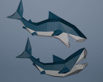 May include: Two stylized, geometric shark illustrations in shades of blue and white. The sharks are depicted with open mouths, revealing sharp teeth, and are set against a muted blue background. The design has a low-poly aesthetic.