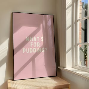 May include: A pink framed poster with the text "What's for pudding?" in white lettering.