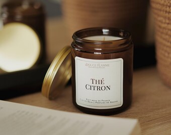 May include: A brown glass candle jar with a white label that reads "DOUCE FLAMME" and "Thé CITRON". The label also says "FAIT MAIN EN FRANCE, CIRE DE SOJA, PARFUMS DE GRASSE".