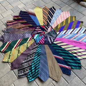 May include: A circular patchwork rug made from a variety of colorful neckties. The rug is made up of 16 different neckties, each with a unique pattern and color. The neckties are arranged in a circular pattern, with the center of the rug being a small, hexagonal piece of fabric.