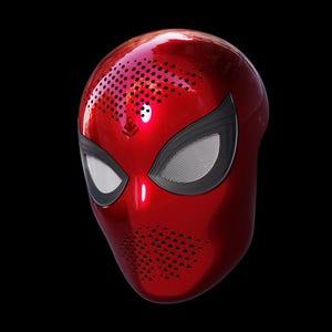 May include: A glossy red helmet with black accents around the eyes, featuring a mesh design. The helmet has a series of small holes for ventilation and a logo on the top. The design is reminiscent of a superhero mask.