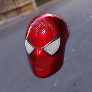 May include: A glossy red Spider-Man mask with white mesh eye coverings and black trim. The mask has small speaker holes on the top and mouth area. The mask is a novelty item.