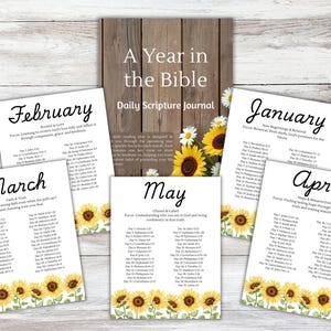 Peut inclure: Un journal de lecture quotidienne de la Bible "A Year in the Bible" avec des plans de lecture mensuels. Le journal présente une couverture en bois et des pages mensuelles individuelles avec des accents floraux et des références bibliques. Les mois de janvier, février, mars, avril et mai sont visibles.