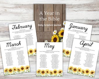 Peut inclure: Un journal de lecture quotidienne de la Bible "A Year in the Bible" avec des plans de lecture mensuels. Le journal présente une couverture en bois et des pages mensuelles individuelles avec des accents floraux et des références bibliques. Les mois de janvier, février, mars, avril et mai sont visibles.