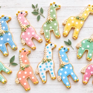 May include: Ten giraffe-shaped sugar cookies decorated with colorful icing in shades of blue, pink, green, yellow, and orange. Each cookie features white polka dots, a textured mane, and small floral accents along the neck and tail area.
