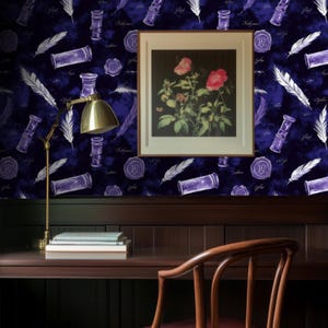 Puede incluir: Un papel tapiz azul oscuro con un patrón repetitivo de tinteros, plumas y sellos de cera. El papel tapiz está detrás de un escritorio de madera oscura con una lámpara, libros y una silla.