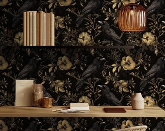 Op de afbeelding: Zwarte en gouden behang met een bloemen- en ravenpatroon. Een houten bureau met een lamp, boeken en decoratieve potten staat voor het behang.