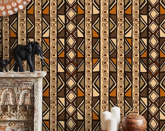 May include: A room decorated with an African-inspired wallpaper featuring geometric patterns in brown, orange, and beige. The wallpaper is accented with a wooden elephant figurine, candles, and a bowl of nuts on a black and gray stool.